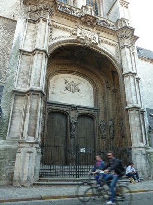 The entrance to St James Church in Sint Jacobs-straat, opposite Building M of the University of Antwerp. There are scallop shells decorating the cloak in the frieze above the door.