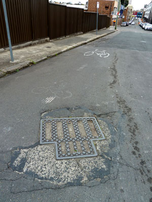 Manhole cover holding together a dilapidated road in Camperdown (Sydney). Photo: meganix 2013.